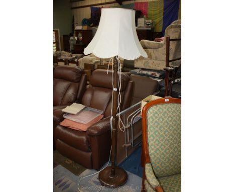 A dark-wood standard lamp with cream fabric shade.