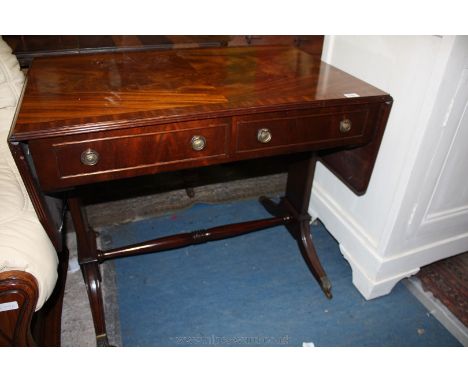 A reproduction Mahogany finished Georgian style Sofa Table having half veneered and cross banded ebony strung top and drop le