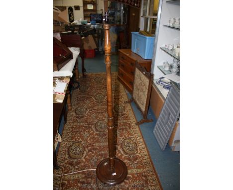 A dark-wood standard lamp, shade absent.