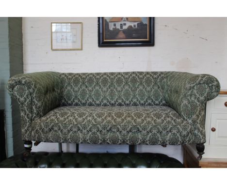 An Edwardian two seater upholstered chesterfield sofa on brass castors, approx. dimensions are width 176cm x depth 80cm x hei