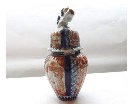 A Japanese Imari covered Jar of reeded tapering circular form, typically decorated in traditional colours with panels of styl