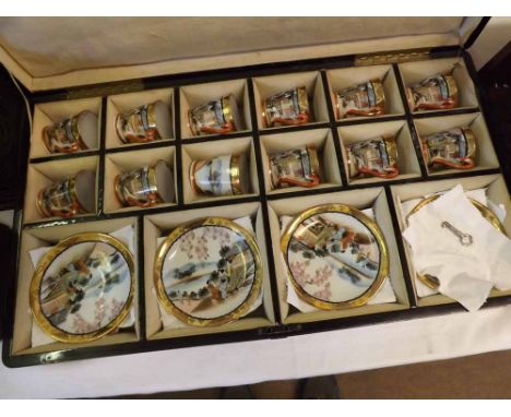 20th Century Japanese lacquered case decorated with birds and palm trees containing a set of twelve cups and saucers, case 20