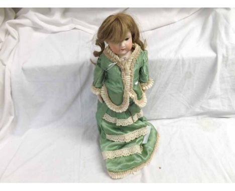 Armand Marseille bisque head and shoulder plate doll with fixed brown glass eyes, painted brows, open mouth showing upper tee