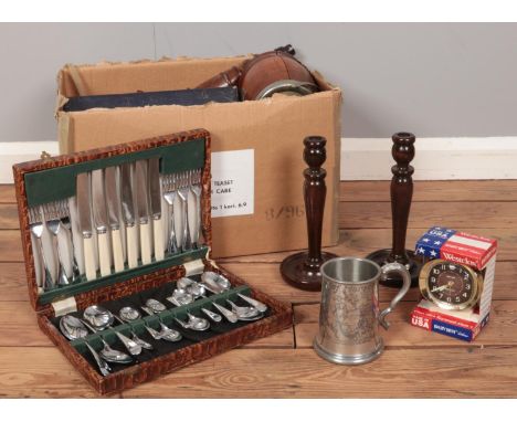 A box of miscellaneous. Silver plate tea set, pair of wooden candlesticks, cased flatware  