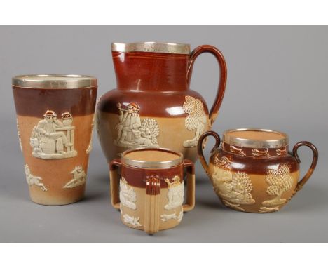 Four pieces of Doulton stoneware, all with silver rims. Jug, beaker, tyg and sugar bowl.  Crack to beaker. Repair to handle o