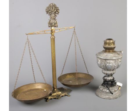A set of brass balance scales along with a metal oil lamp converted to electric.  