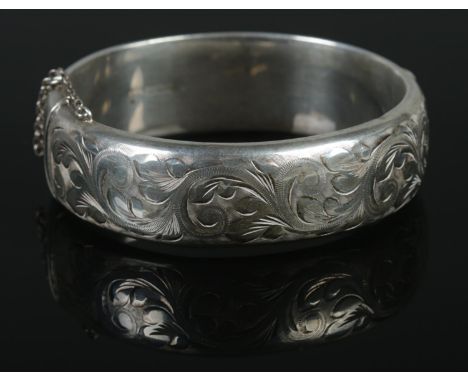 A silver hinged bangle, assayed for Birmingham, 1989, by EJ Ltd. Total weight: 27.11g.  