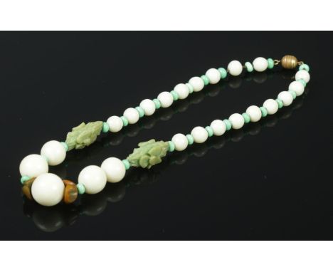 A carved Jade necklace. L: 21cm.  Stamped Made in France on the clasp.