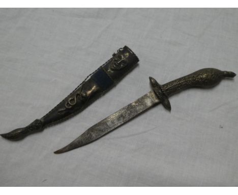 An ornamental dagger in silvered scabbard decorated with mask and snake emblems