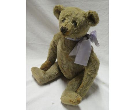 An old plush covered Steiff teddy bear with metal ear button, pointed snout and articulate limbs, 15½" long (af)