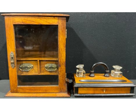 A Victorian/Edwardian oak smokers cabinet, single glazed door enclosing fitted interior with two drawers and open shelf, 36.5