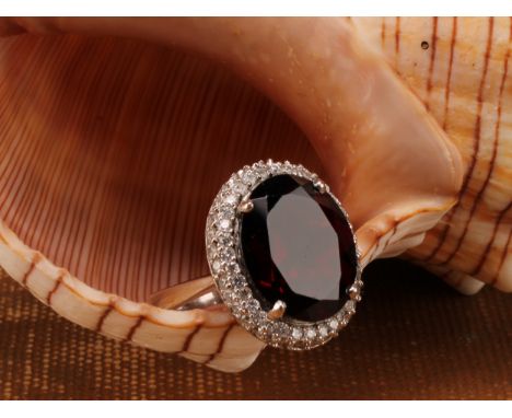 18ct white gold Almandine/Pyrope Garnet and Diamond ringThe ring is set with an oval brilliant cut Almandine/Pyrope Garnet th