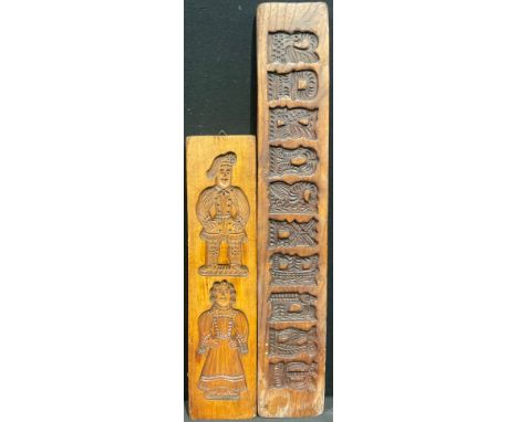 Treen - a Dutch speculaas biscuit or gingerbread mould, intaglio carved with 18th century figures, 44cm long; another, carved