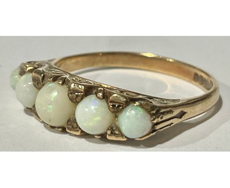 A 9ct Rose Gold Graduated White Opal Ring; the ring set with five graduated round cabochon white opals that vary in size from