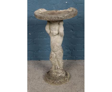 A concrete bird bath formed as a child raising dish. Approx. dimensions 41cm x 76cm.  Basin damaged towards rear.