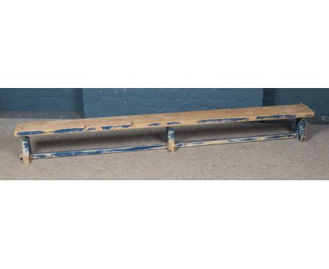 A pine bench with painted legs. Approx. dimensions 239cm x 28cm x 19cm.  
