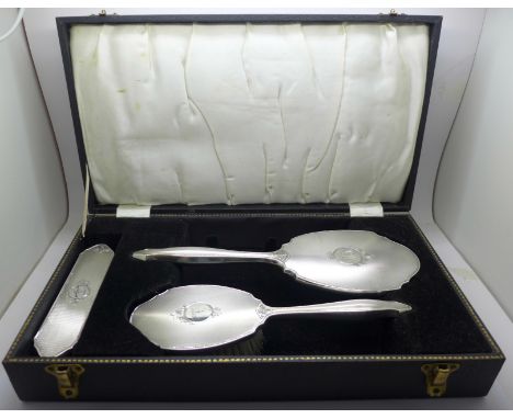 A vintage three piece silver vanity set, hand mirror and two brushes, Birmingham 1963, W I Broadway &amp; Co., cased, (with i