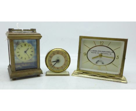 Three clocks; a small carriage clock with decorative panels, a Smiths clock and a T.A. Woods advertising clock 