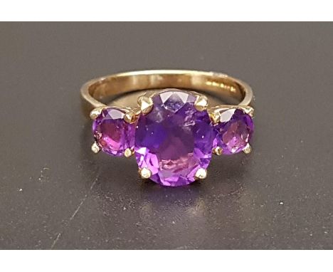 GRADUATED AMETHYST THREE STONE RINGthe central oval cut amethyst approximately 2.5cts flanked by round cut amethysts totaling