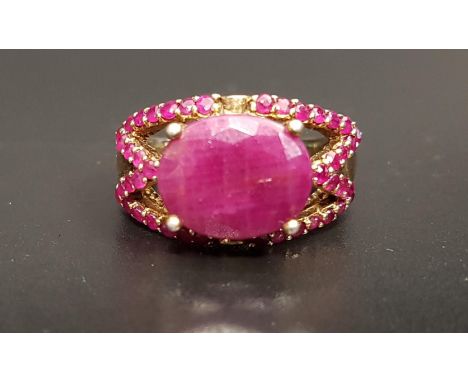 RUBY DRESS RINGthe large central oval cut ruby approximately 4.5cts in ruby set pierced setting, on silver gilt shank, ring s