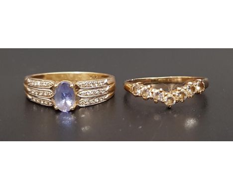 BLUE GEM AND DIAMOND DRESS RINGthe central oval cut blue gemstone flanked by three rows of diamonds to each shoulder, on four