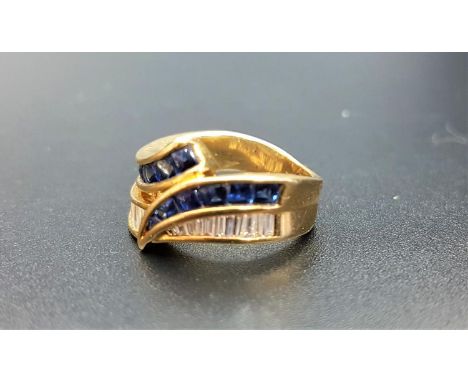 ATTRACTIVE DIAMOND AND SAPPHIRE CROSSOVER RINGwith channel set baguette cut diamonds and cabochon sapphires, on eighteen cara