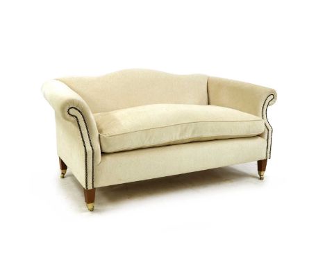 A modern cream upholstered two seater sofa, in the traditional style, the serpentine back above cushioned seat on square tape