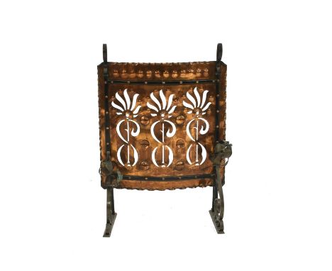 An Arts and Crafts copper and wrought iron firescreen, with pierced decoration, 88cm wide, 61cm high, together with a brass f