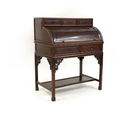 A Chinese style hardwood cylinder bureau, with three drawers over a cylinder concealing an arrangement of pigeonholes, on squ