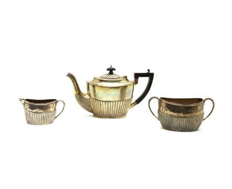 A matched silver three-piece tea set, the teapot, Chester, 1906, the sugar bowl and milk jug worn marks, 14.5cm (3)Condition 