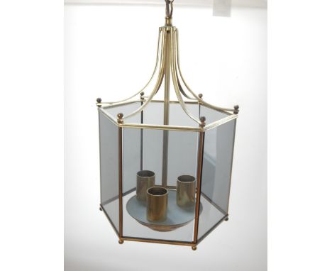A hexagonal glazed brass hall lantern, a glass ceiling shade, a two branch brass wall light together with a circular mahogany