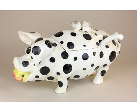 An Italian pottery soup tureen in the form of a pig with an apple in its mouth, acorn shaped handle on its back, in black and