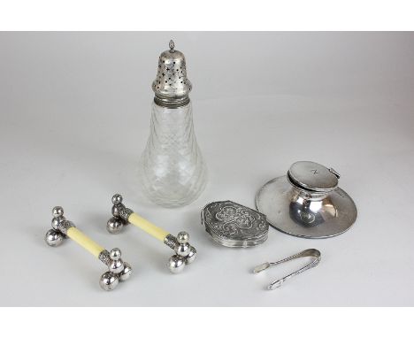 An Edwardian silver inkwell, a pair of Edwardian silver plate and ivory knife rests, an embossed silver trinket box (a/f), a 