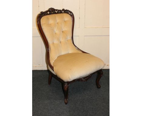 A 20th century mahogany framed button back nursing chair on cabriole legs