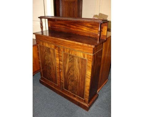 A Victorian mahogany chiffonier with raised shelf back above gilt metal mounted drawer and twin cupboard doors, on plinth bas