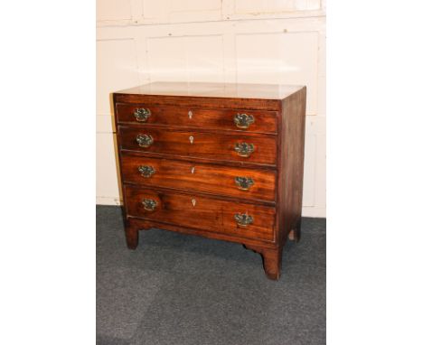 A George III mahogany small chest with boxwood stringing and zigzag inlaid frieze above four graduated drawers, on bracket fe