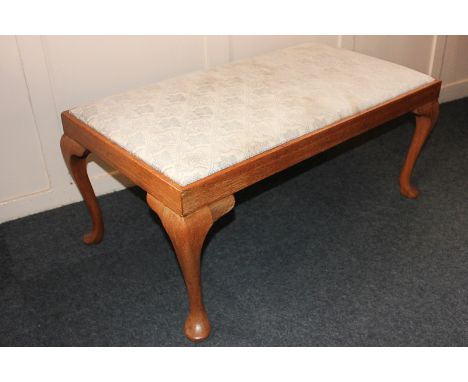 A large rectangular upholstered stool on cabriole legs, 104cm