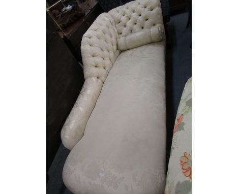 An Edwardian mahogany and cream, floral upholstered chaise longue, with button back, and bolster cushion, on turned legs and 
