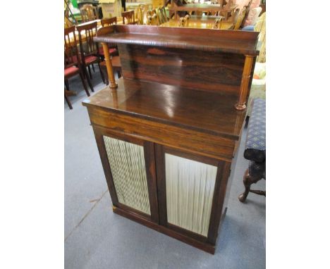 An early 19th century rosewood chiffonier having a shelf over turned pillars, above a frieze drawer and twin doors with pleat