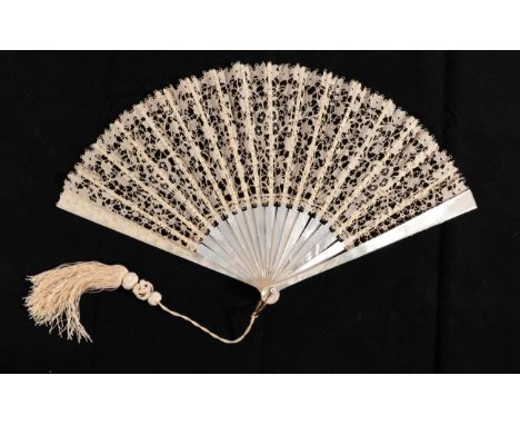 A Late 19th or Early 20th Century White Mother-of-Pearl Fan, mounted with a leaf of Carrickmacross guipure lace. The design i