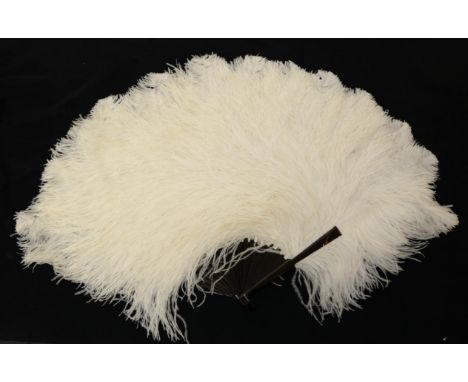 A Circa 1900 White Ostrich Feather Fan, the frothy feathers mounted on a dark tortoiseshell with light mottling, curling gent