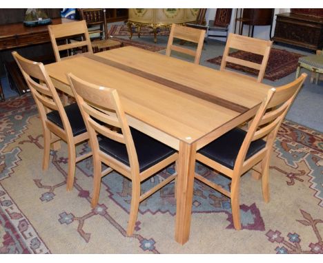 A modern solid oak dining table, 160cm wide; and six ladder back chairs with brown leather seats 