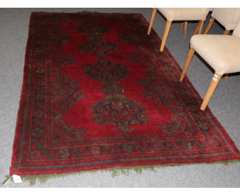 An Ushak Carpet, the tomato red field with a column of medallions enclosed by rosette borders, 260cm by 158cm