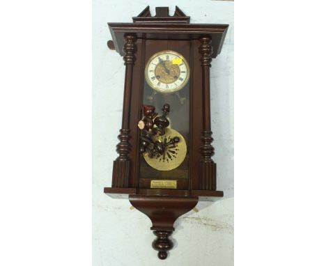 A Victorian style mahogany Vienna wall clock, with enamel dial. 102 cm high.