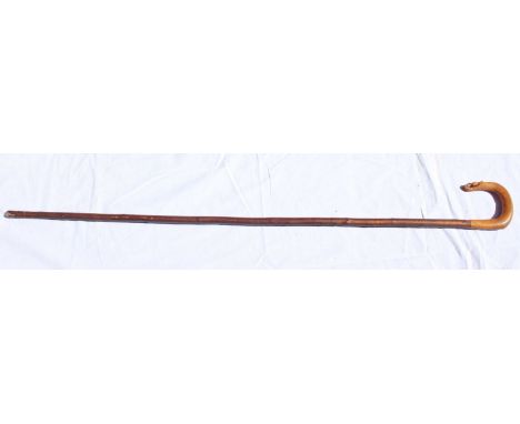 An unusual walking stick with shepherd crook amber coloured handle, carved with a thistle