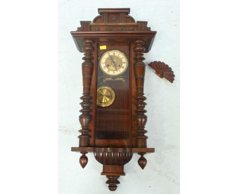 A Victorian Vienna wall clock, with turned column sides and finials, with enamel and brass dial, and pendulum. 99 cm high