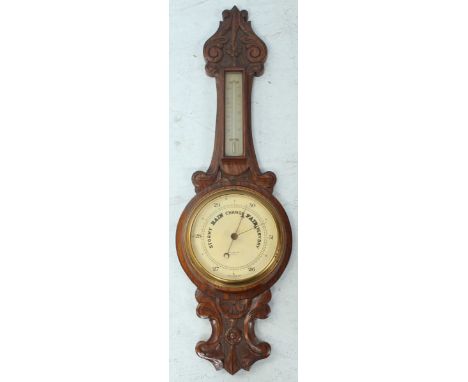 An early 20th century carved oak aneroid banjo barometer by Percy Harrison, with thermometer. 75 cm long