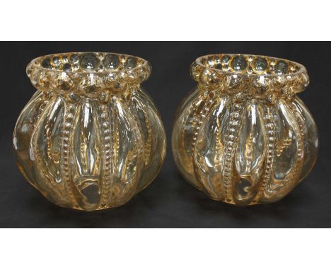 A pair of transparent press moulded glass light shades of globular form, with moulded lobe and bead decoration. 23cm in heigh