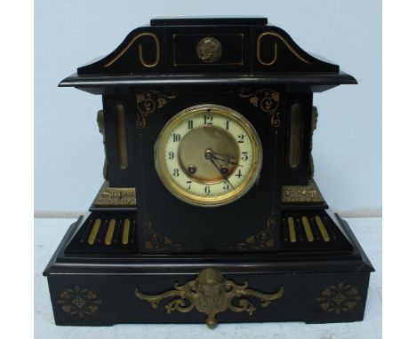 A Victorian black slate mantel clock, with applied gilt metal mask mounts and handles. 48 cm high.