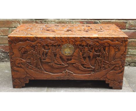 A Chinese carved camphor wood trunk, decorated with sailing junks and dragons. 80 cm wide
